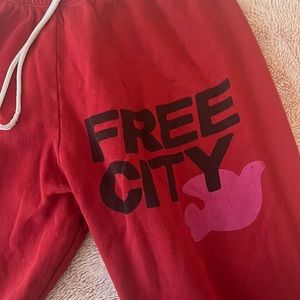 Red free city sweatpants with black writting and light pink/ purple logo.